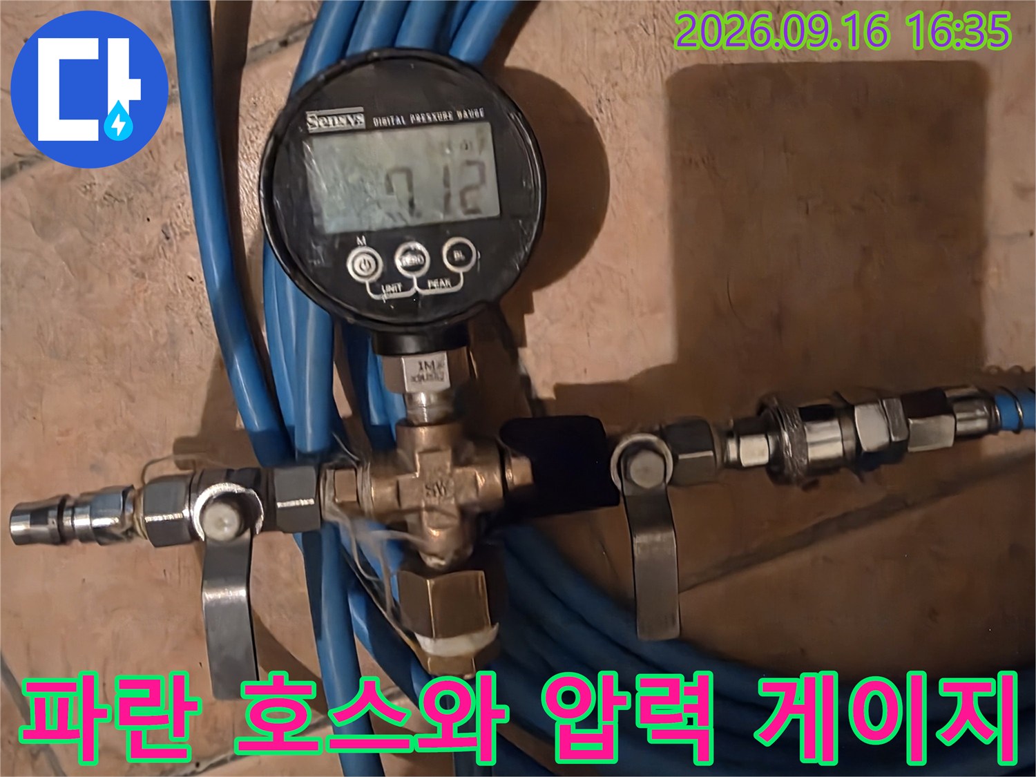 파란색 호스가 연결된 밸브와 디지털 수압 측정기
