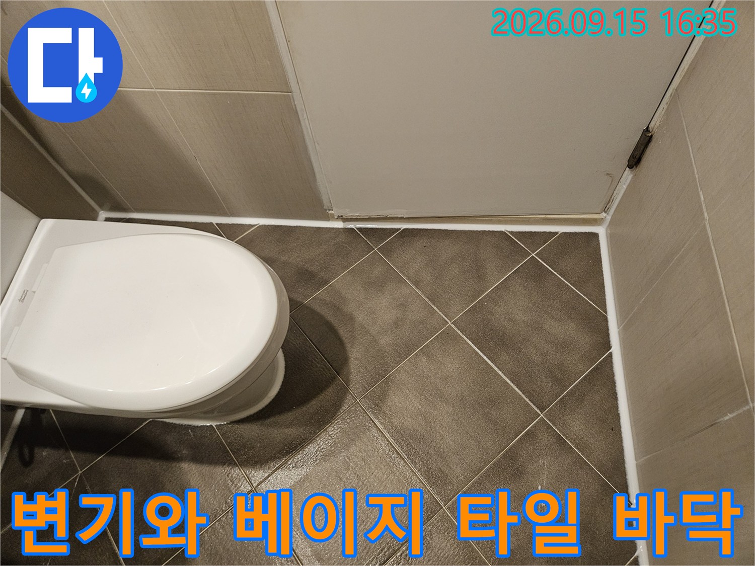 변기 옆면과 사각형 모양의 욕실 바닥 타일 모습
