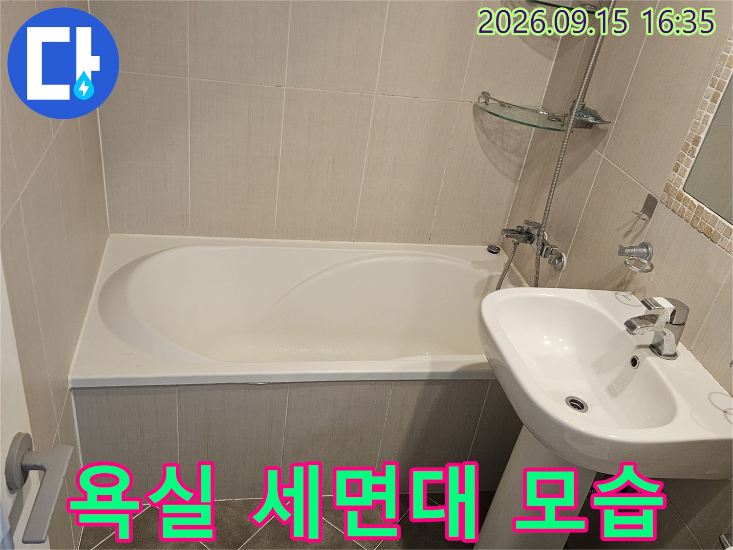 정리된 상태의-화장실 세면대와 베이지색 타일 벽
