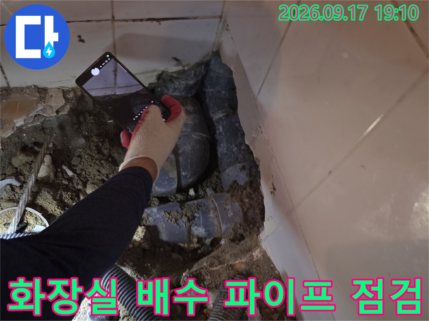 굴착된 화장실 바닥-연결 부위의 배관 균열 여부를 확인하는 모습