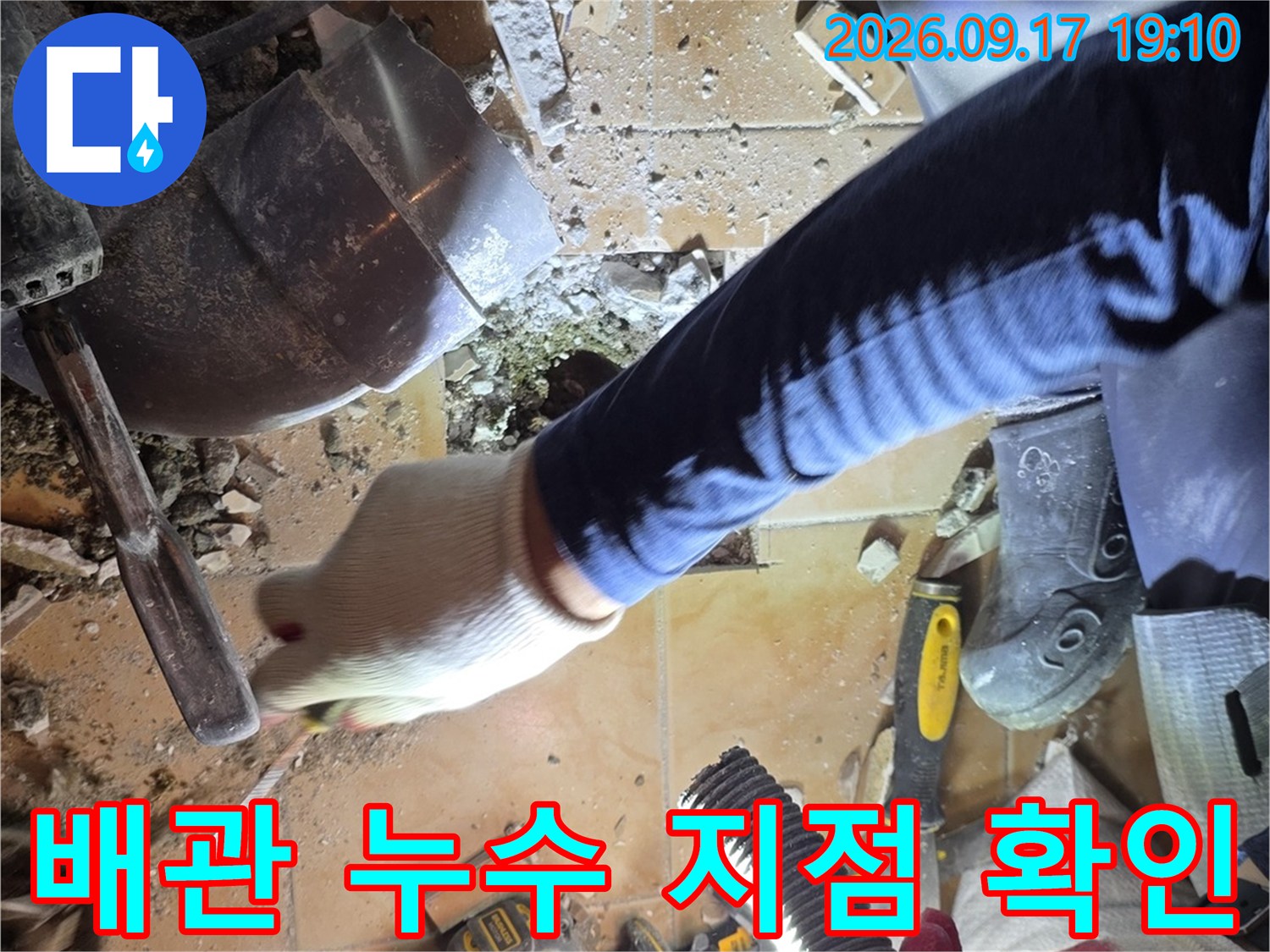 화장실 바닥 굴착 후 배수 파이프를 점검하는 모습