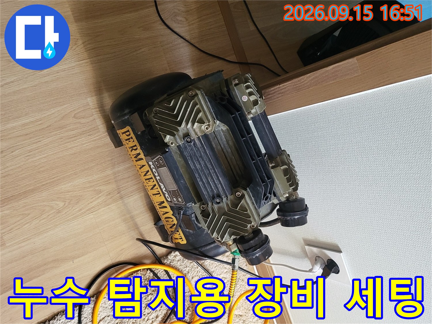 바닥에 놓인 노란색 호스와 연결된 전문 압력 테스트 장비