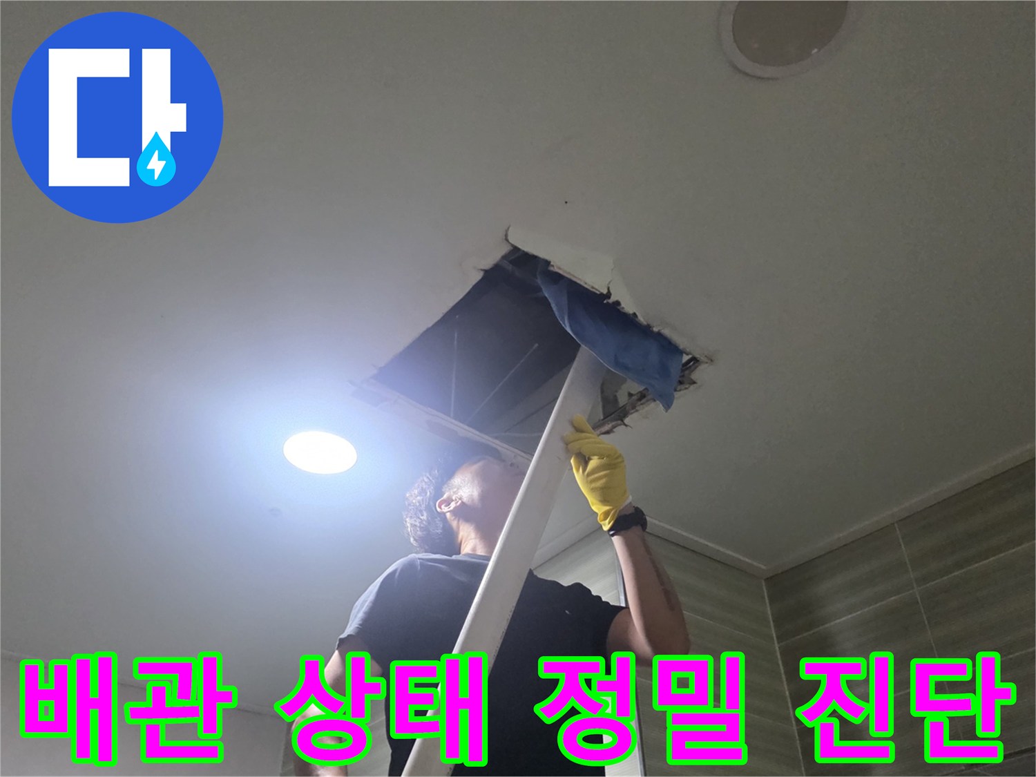 조명을 비추어 천장 내부의 배관 연결 부위를 점검하는 엔지니어