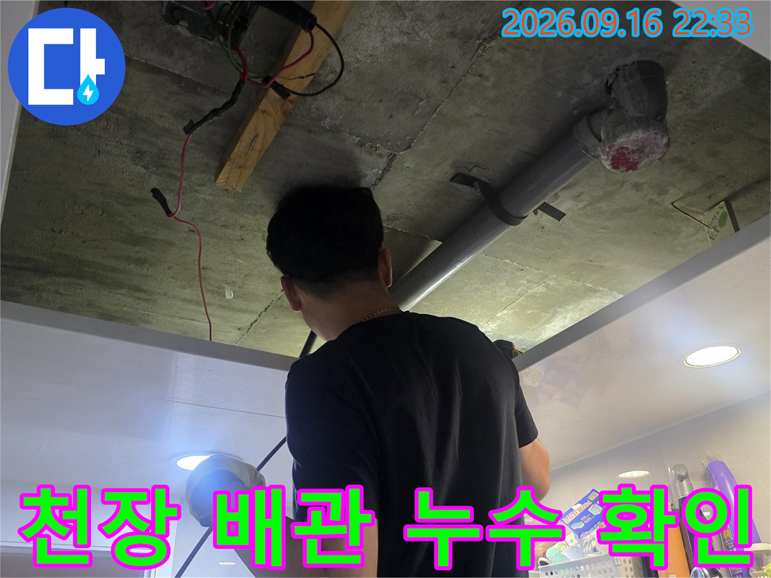 천장 점검구 내부의 배관 연결 부위와 주변 오염 상태를 점검합니다.