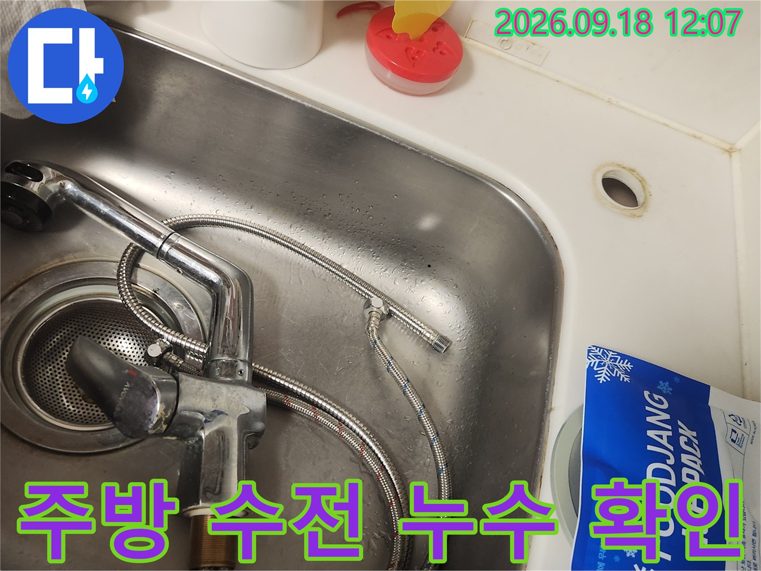 싱크대 배수구 주변에 위치한 노후된 주방 수전의 상태입니다.